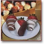 3 strawberries dipped in milk and white chocolate, decorated with a chocolate drizzle