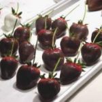 Several strawberries with stems which have been dipped in chocolate