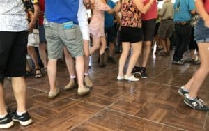 People dancing showing legs only on brown wood floor