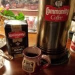 Coffee Container showing red Community Coffee label, cups, coffee setup