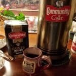 Package and canister of Community Coffee and The Stockade Bed and Breakfast mug with coffee.