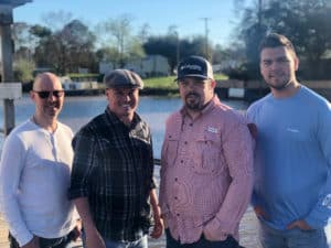 Foret Tradition Band members standing in front of river