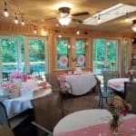 Room with round tables decorated in pink and white.