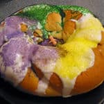 Round cake decorated with green, gold and purple icing