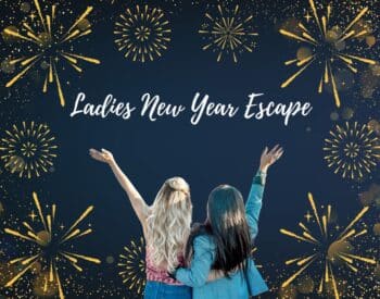 2 ladies with their hands up with blue background and gold stars