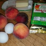 Red peaches, 2 eggs, butter, peach crisp mix on table