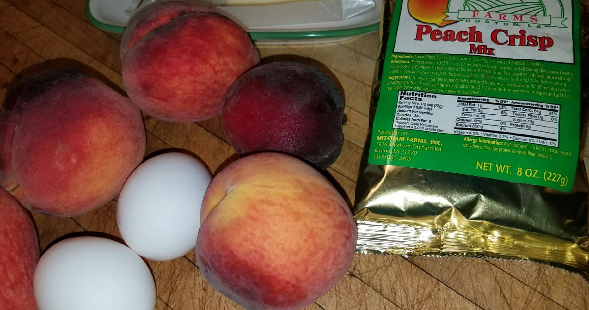 Red peaches, 2 eggs, butter, peach crisp mix on table