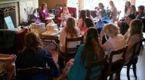 Ladies sitting in living room with bride opening presents