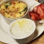 Plate with spinach frittata, white grits, strawberries