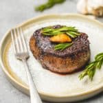 Filet Mignon steak on plate with fork, ready to eat