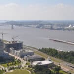 Ariel photo of Baton Rouge Downtown, bridge, barges on Mississippi River against a blue sky with high white clouds